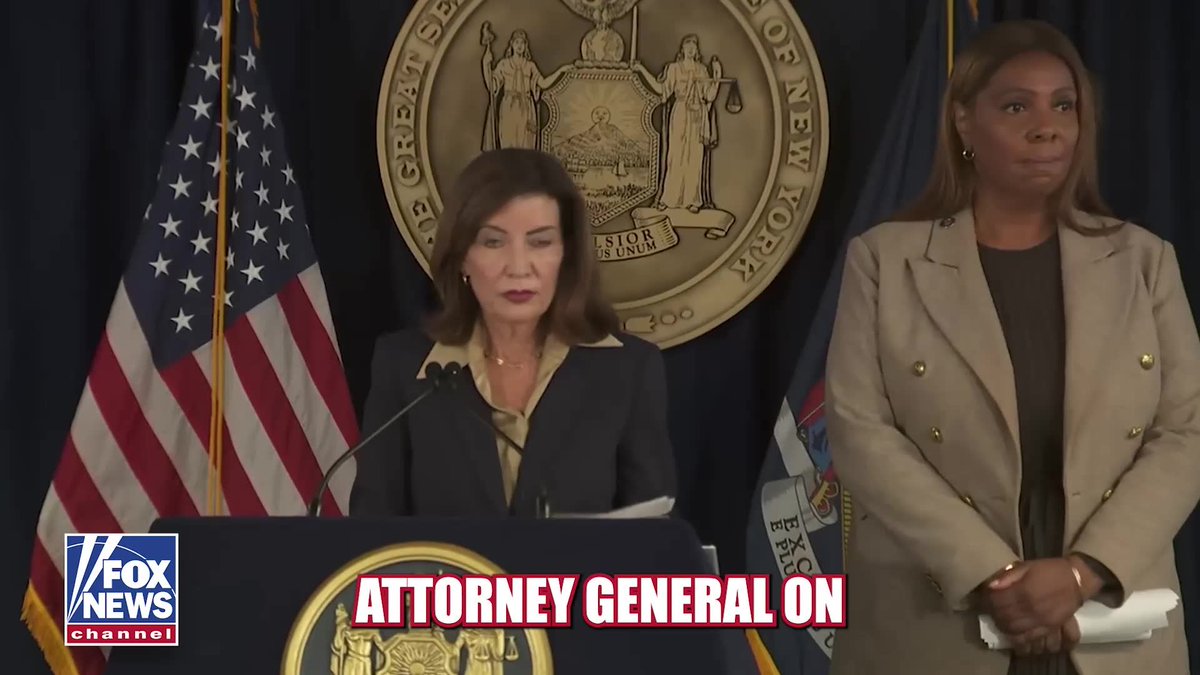 A Fox News Channel broadcast of New York Governor Kathy Hochul speaking at a podium with the New York state seal, standing beside another woman in a tan blazer, with a chyron that reads 'ATTORNEY GENERAL ON'.