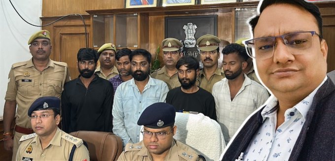 A photo showing several men in police uniforms alongside other men in civilian clothing in an official room featuring the Indian national emblem.