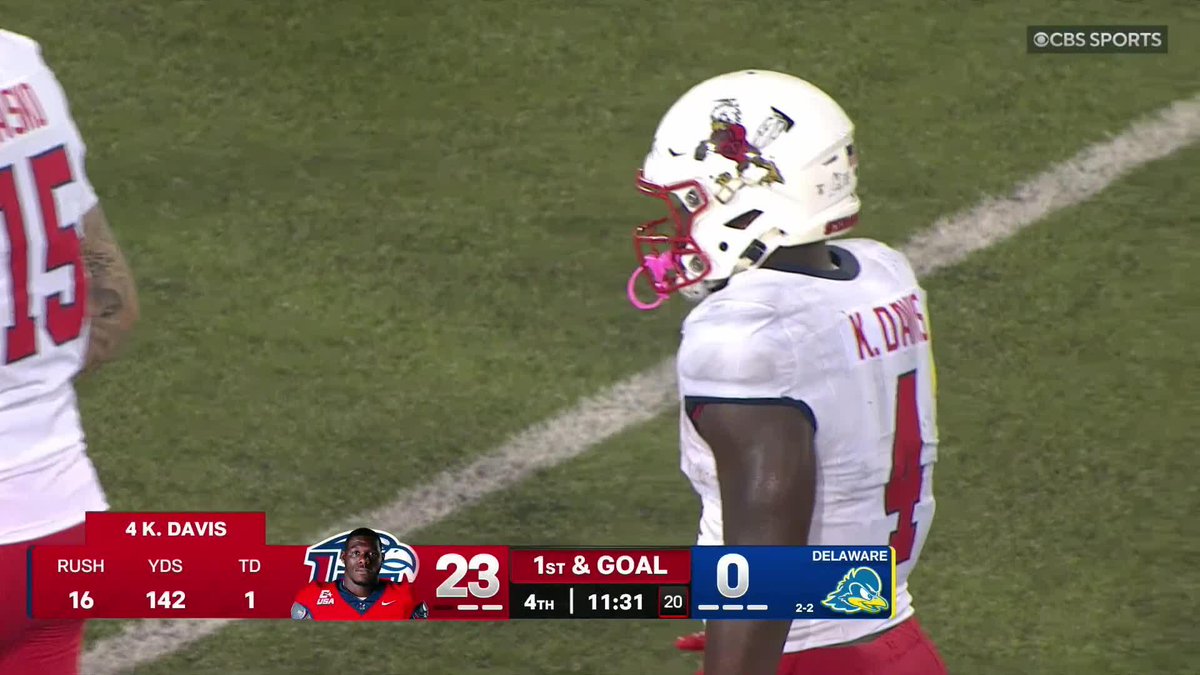The image shows Liberty running back #4 K. Davis on the field during a game against Delaware, with the scoreboard indicating Liberty leads 23-0 in the 4th quarter with 11:31 remaining. The stats displayed show Davis had 16 rushes for 142 yards and 1 touchdown, highlighting his strong rushing performance that aligns with the post noting his 147 rushing yards and 2 TDs on 8.6 yards per carry.