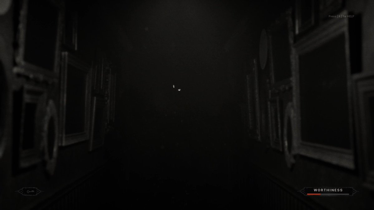 A dark, eerie first-person view down a dimly lit hallway lined with framed pictures, with 'WORTHINESS' displayed at the bottom right and 'Press [K] for HELP' at the top right, suggesting a horror video game.