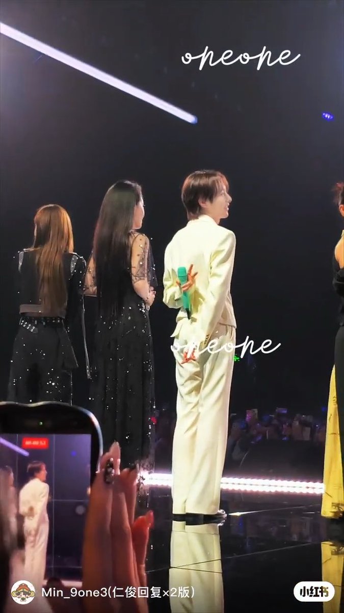 A concert stage scene with performers seen from behind, including one in a white suit holding a microphone, with the watermark 'ohone' and 'Min_9one3' visible along with the Xiaohongshu (小红书) logo.