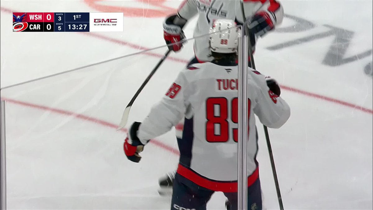 Hockey player Tuch #89 of the Washington Capitals celebrates with teammates after scoring his first goal as a Capital, as the scoreboard shows WSH and CAR tied 0-0 with 13:27 remaining in the 1st period.