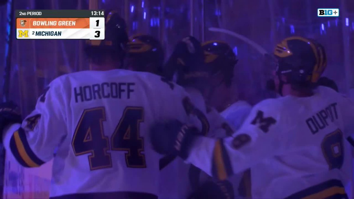 Michigan hockey players, including Horcoff #44 and Dupati, celebrate on the ice during a game against Bowling Green, with the scoreboard showing Michigan leading 3-1 in the 2nd period with 13:14 remaining, following Michael Hage's goal.