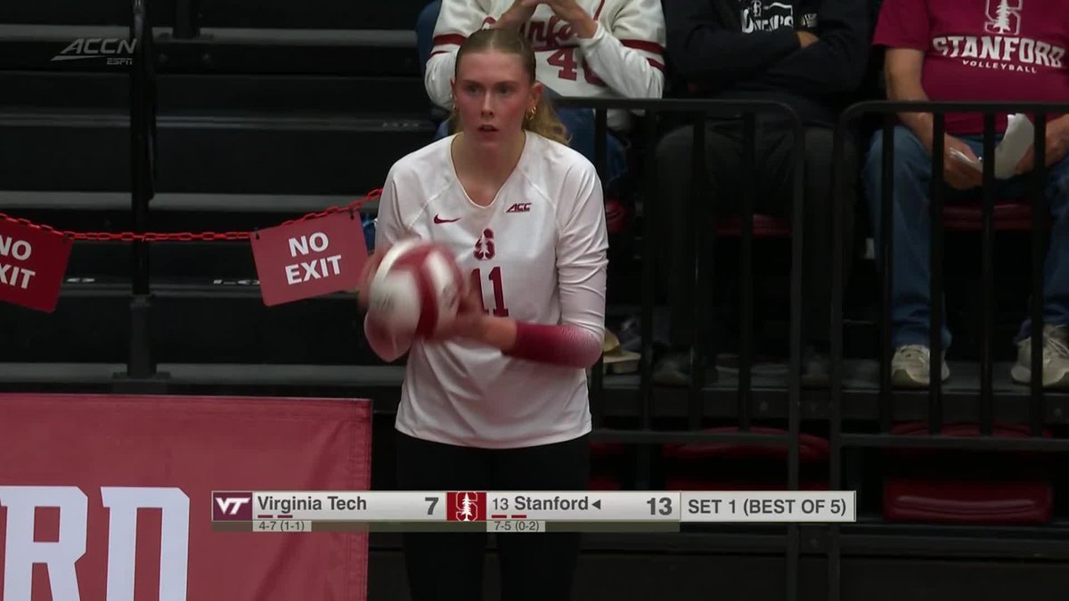 Stanford women's volleyball player #11, a blonde woman in a white jersey, holds a ball at the service line during a match against Virginia Tech (VT 7, Stanford 13, SET 1) broadcast on ACCN.