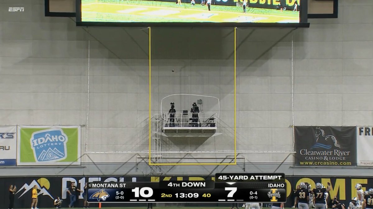 A football game between Montana State (10) and Idaho (7) is shown on ESPN during the 2nd quarter with 13:09 remaining and 40 on the play clock, with a '45-YARD ATTEMPT' on 4th down; goalposts and camera operators on a lift are visible in the stadium.
