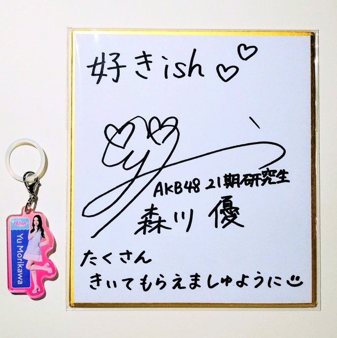 An autographed shikishi (color paper) from AKB48 21st generation member Yu Morikawa, featuring her signature, handwritten message, and an accompanying acrylic keychain with her photo and name.