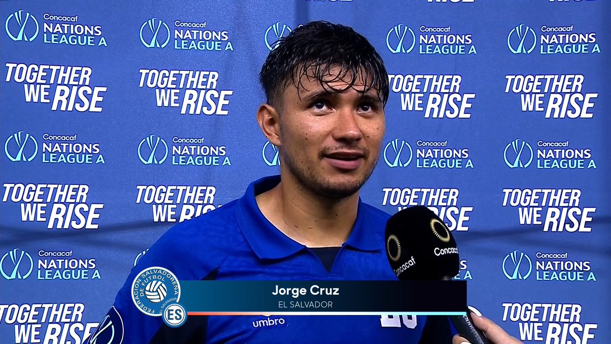 A young soccer player with damp hair, identified by an on-screen graphic as Jorge Cruz of El Salvador, is being interviewed post-match, wearing a blue Umbro jersey in front of a blue backdrop featuring the Concacaf Nations League A logo and the slogan "Together We Rise." His words about rising together with his teammates align with the tournament's promotional message displayed prominently behind him.