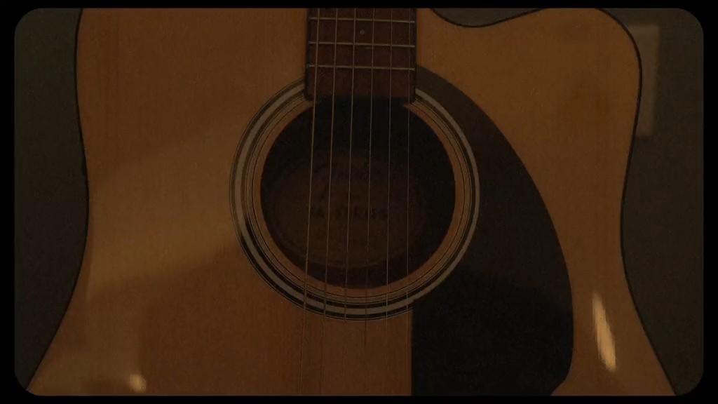 Image 7: A close-up, dimly lit photograph of an acoustic guitar focusing on its soundhole and strings.