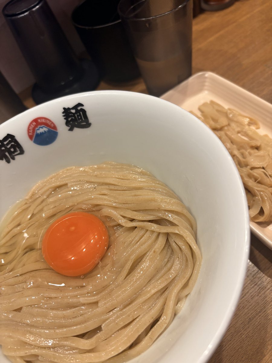 0kara1_man's tweet photo. 夕方頃、出張中に一人で「中華そば 桐麺 梅田店」へ初訪問。

↓

夕方のピークを少し過ぎた時間帯でも、外待ちは5人。人気の高さがうかがえた。

↓

まぜそばタイプで、まず印象的なのはビジュアルの美しさ。太麺に卵をしっかり絡ませていただく。

↓

ここは“麺が勝負”のお店だと感じた。太麺そのものの美味しさがダイレクトに伝わり、ツルツル、ズルズルと一気に食べ進めてしまう。

↓

麺の下には塩ダレ。やや塩味が強めに感じたが、麺の旨さとタレの旨さをストレートに味わえる一杯だった。

↓

追加したメンマも大正解。長いタイプで麺と絡ませると食感が加わり、かなり美味しい。

人気があるのも納得のお店だった。

#桐麺