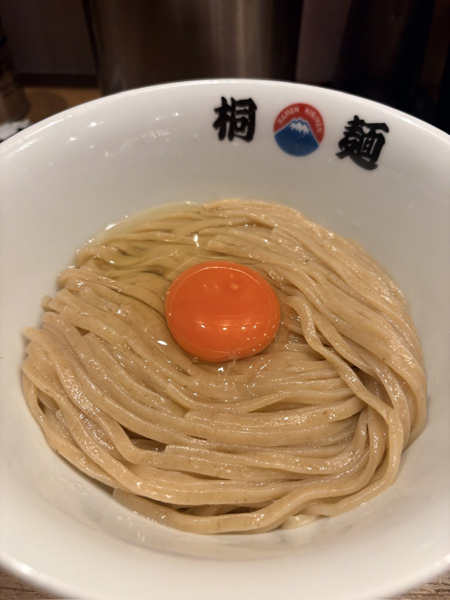0kara1_man's tweet photo. 夕方頃、出張中に一人で「中華そば 桐麺 梅田店」へ初訪問。

↓

夕方のピークを少し過ぎた時間帯でも、外待ちは5人。人気の高さがうかがえた。

↓

まぜそばタイプで、まず印象的なのはビジュアルの美しさ。太麺に卵をしっかり絡ませていただく。

↓

ここは“麺が勝負”のお店だと感じた。太麺そのものの美味しさがダイレクトに伝わり、ツルツル、ズルズルと一気に食べ進めてしまう。

↓

麺の下には塩ダレ。やや塩味が強めに感じたが、麺の旨さとタレの旨さをストレートに味わえる一杯だった。

↓

追加したメンマも大正解。長いタイプで麺と絡ませると食感が加わり、かなり美味しい。

人気があるのも納得のお店だった。

#桐麺