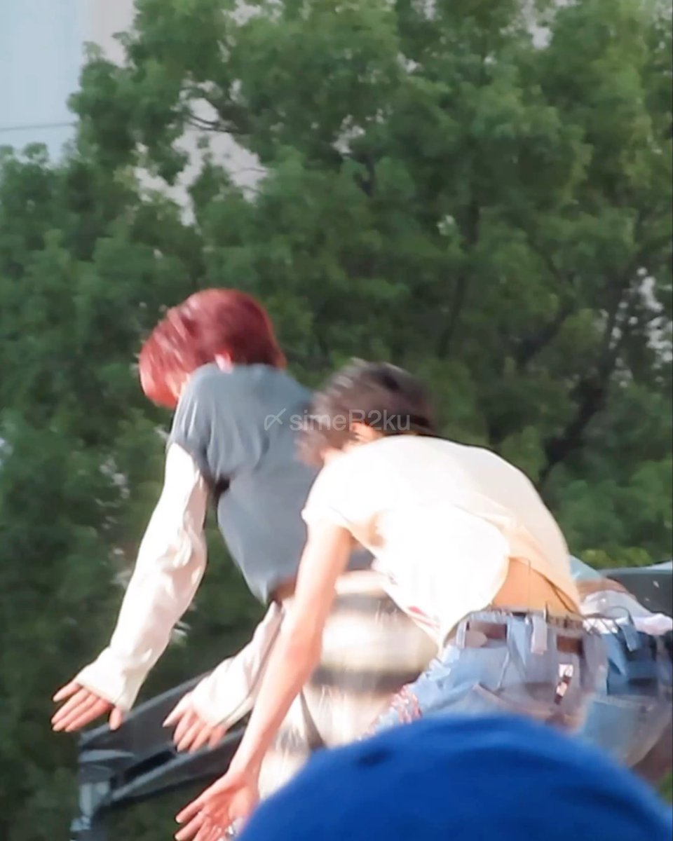 Two people with red hair lean over a car roof outdoors with trees in the background; the image has a 'simeP2ku' watermark.