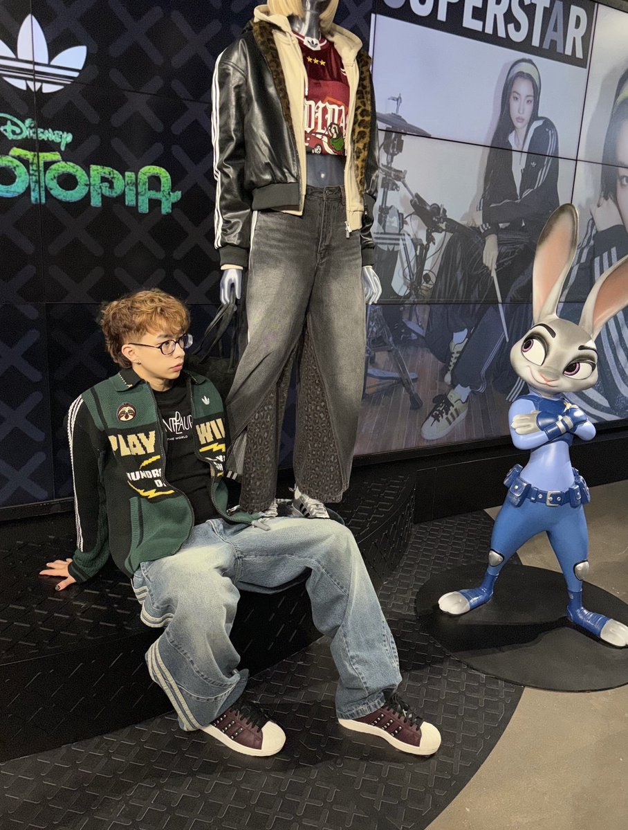 ZootopiaToday's tweet photo. 🛍️ Merchandise Watch: adidas × Zootopia Apparel Collection 🦊🐰👟✨
Even adidas stores have invited Nick and Judy inside! 😭🏙️
Disney fans, get ready to scream — adidas Originals × Zootopia has officially stepped out of the movie and into real life!
✨ Judy-inspired brown jacket
The retro Three Stripes give it plenty of streetwear energy, while the panelled design adds just the right amount of cool detective DNA. 🕵️‍♀️🐰
💚 Nick-inspired green jacket
Green meets yellow and white for a laid-back, roguishly charming look that feels perfectly Nick Wilde.
And as a Nick × Judy partner outfit? I’m locking this one in. 🔒🦊🐰
👟 Superstar sneakers
The classic shell toes get their own Zootopia graphics, plus special details on the padded tongues and heels. Comfortable underfoot while still bringing plenty of style.
🎤 And the store itself joined the collaboration too!
A giant record-wall installation, plus Judy and Nick displays, makes almost every corner feel ready for a cinematic photo shoot. 📸✨
The relaxed fits are easy to layer and style — put one on and you’re basically ready to become an honorary citizen of Zootopia. 🌆😂
So before your size disappears…
grab your own “Flash” and hurry over! 🐌💨
🔁 Share this with your Zootopia partner — because this collection is practically begging for a Nick & Judy matching outfit. 🦊💚🐰