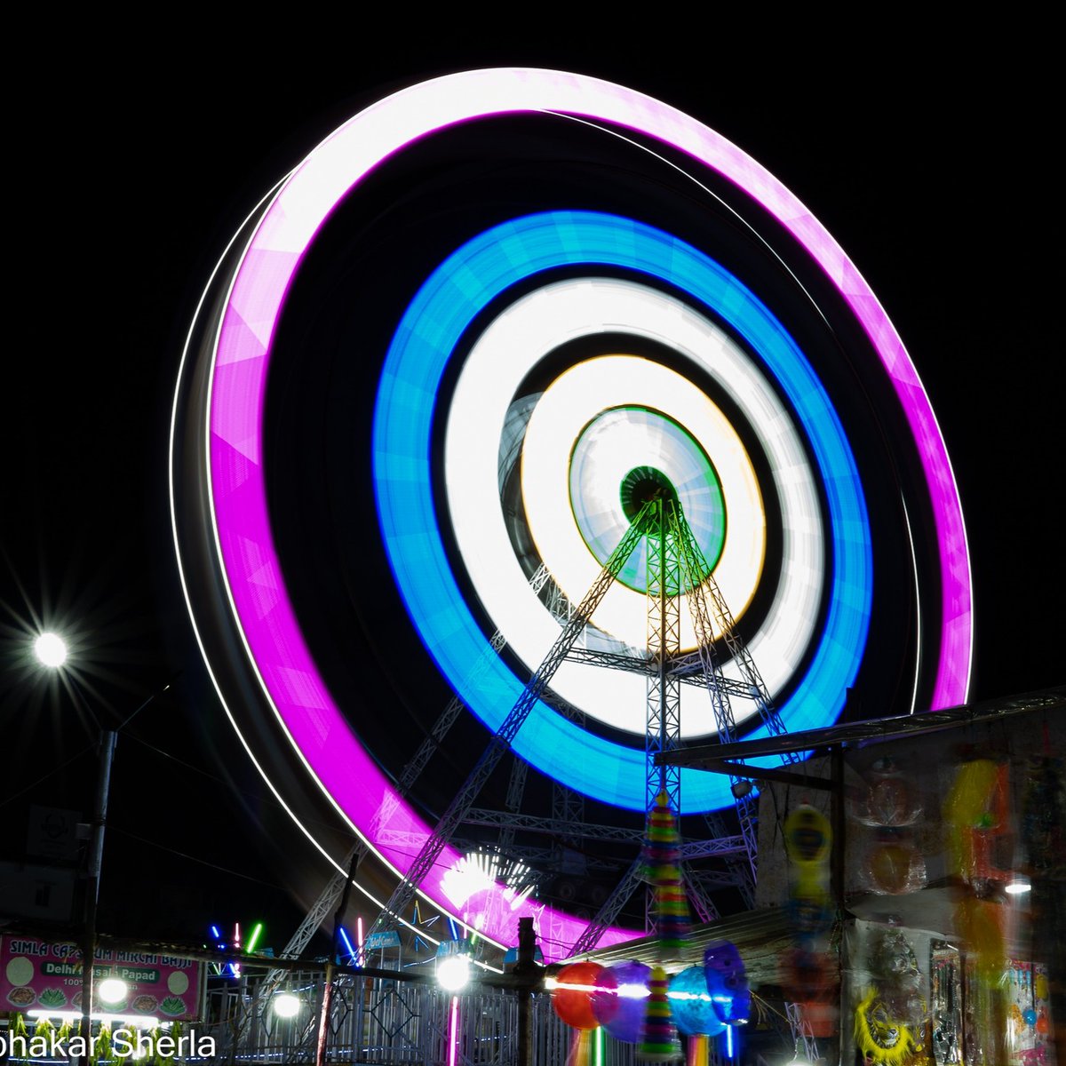 meaddcattch's tweet photo. A giant wheel lights up a small exhibition in Hyderabad, India. https://t.co/9PDqcqTrY7