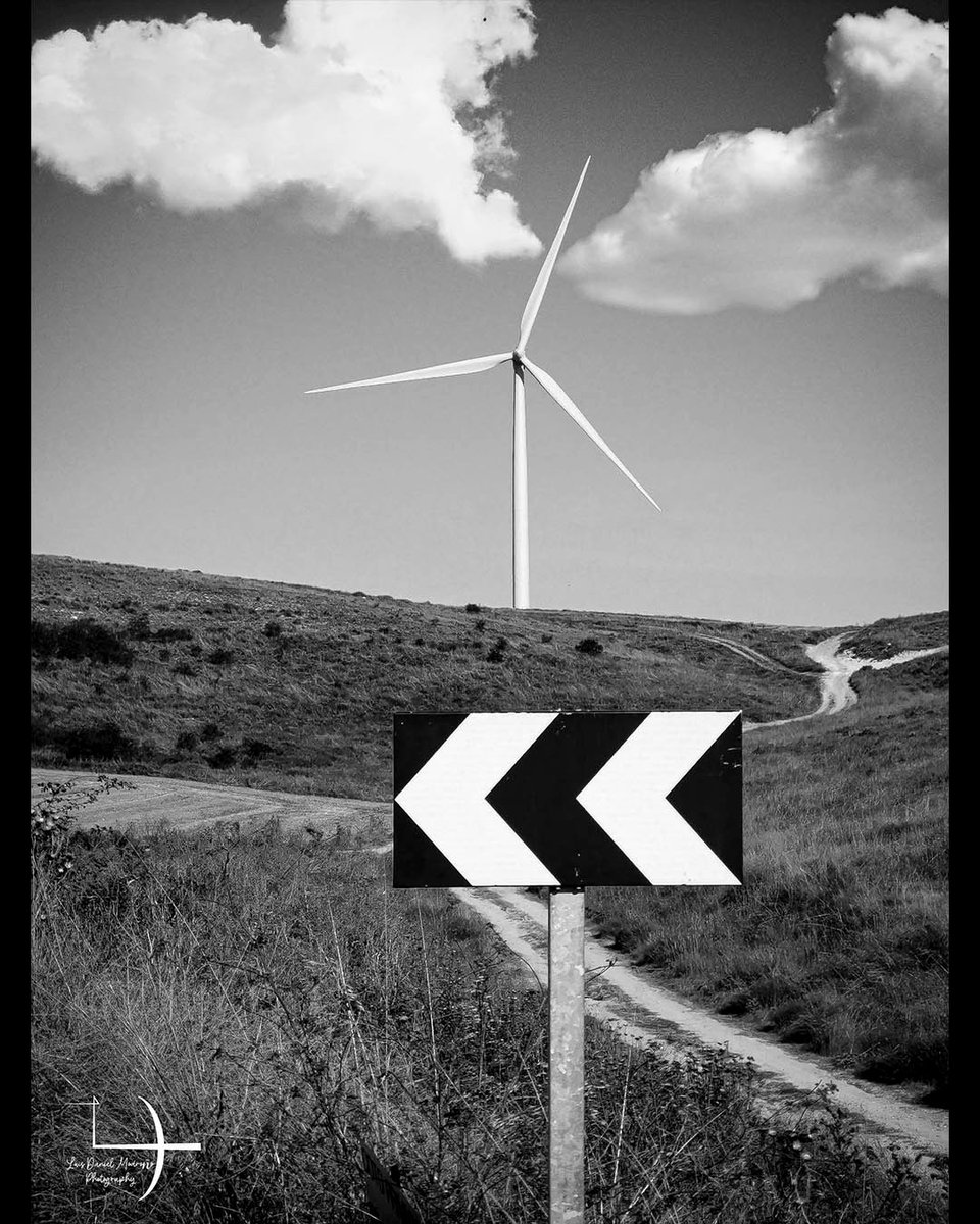 alexjuniiior's tweet photo. El viento no conoce atajos. Entre aspas en movimiento y una flecha inmóvil, el camino se curva hacia lo desconocido. ¿Seguirías este desvío? ¿Qué música elegirías para recorrerlo? https://t.co/Qwbn5eFe7h