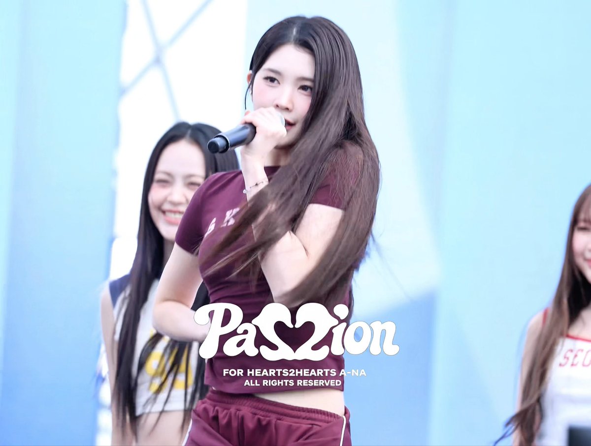 A K-pop performance photo of Hearts2Hearts member A-na singing into a microphone, with the text "PASSION FOR HEARTS2HEARTS A-NA ALL RIGHTS RESERVED".