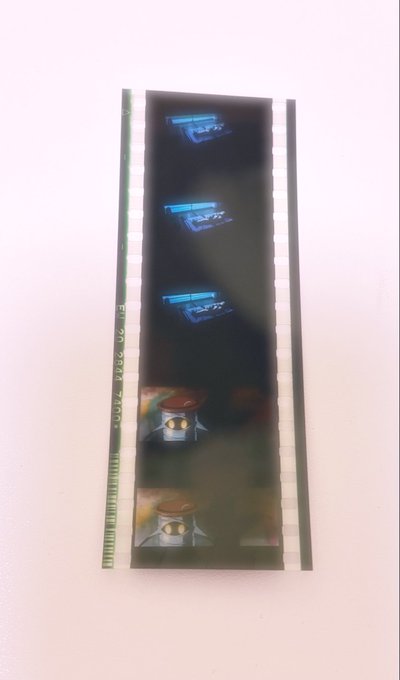 A strip of undeveloped or partially developed 35mm film negative showing faint frames against a white background.