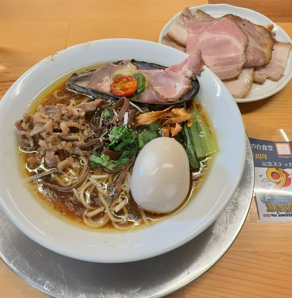 kakusankibouRT's tweet photo. 今日は秋田県にかほ市象潟の【湯の台食堂】に行って来ました🚗☁️

今日、明日は湯の台食堂9周年記念の特別なラーメンが提供されます㊗️

9周年おめでとうございます🎉㊗️🎊

9年前、湯の台食堂は東京の有名店、麺屋七彩等で修行した現店主が湯の台食堂を継いで本格的なラーメン屋として再スタート🍜

秋田は何もないと言われてる、しかも湯の台の店のある所は言っちゃなんだけど、本当に何もない所、そんは場所にこんなに凄いラーメン店を作ってくれた事にホントに感謝しかないデス😆

て事で注文は今日、明日限定の9周年記念限定、秋田の恵みを味わう、特別な一杯。TP味玉、チャーシュー❗️替え玉✖︎2‼️

今日は間違いなく、これ喰うに決まってるでしょう！😆

食材から麺まで秋田の魅力を詰め込んだこの9周年だけの特別なラーメンだ🍜

スープは鶏の旨味と貝と魚、いずれも全部地元産、比内地鶏、つどいファーム鶏、小砂川産ムール貝、金浦産沖キス等を使ったスープで正に秋田スペシャル中華そば🍜

そして麺はこの9周年記念ラーメンの為に打った多加水中細ストレート麺。

モチモチでツルツルの中細麺はしっかりとコシもあって啜りやすく、これぞ中華そばな麺。

ラーメンにムール貝が乗ってるのも芸術的でもあって良い！
めっちゃオシャレだ。
このムール貝もやはりスープに絡んでるんだろうか？

スープは鶏と魚介のスープだけど、とても鶏の旨味と魚介の旨味、どっちも感じられて正に特別な一杯だ🍜

ラーメンって自分の場合、ガンガン啜って食べるイメージなんだけど、このラーメンは一口一口をしっかりと味わいながら食べる、そんな感じになってしまう😅

旨過ぎだったので、全然足りなくて替え玉（✖︎2）を追加注文！

いやぁ〜とても旨かったデス！
ご馳走様でした😋
来年は10周年になりますね！

（もしかしたら替え玉代払い忘れたかも？😅
駐車場は向かい側の元鶴泉荘だった所にも止めていいのかな？）