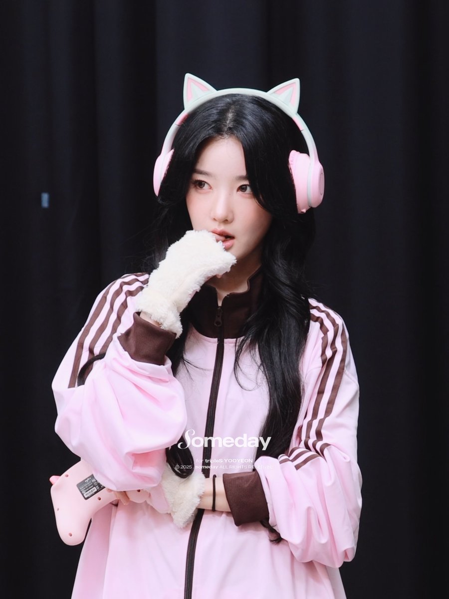 A woman with long dark hair wears pink cat-ear headphones and a pink Adidas-style jacket, with text reading 'Someday by tripleS YOOYEON'.