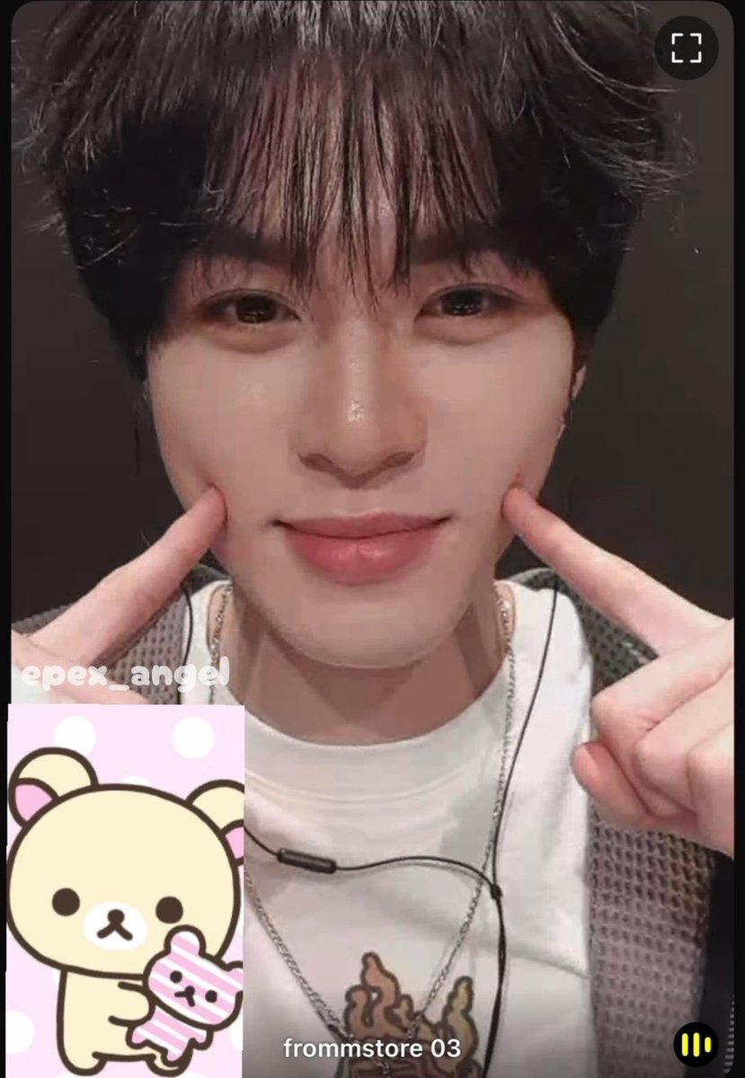 A young man with dark hair takes a close-up selfie pointing to his cheeks, wearing a white shirt with a necklace, featuring the "frommstore" app interface with a Rilakkuma sticker and "epex_angel" text overlay.