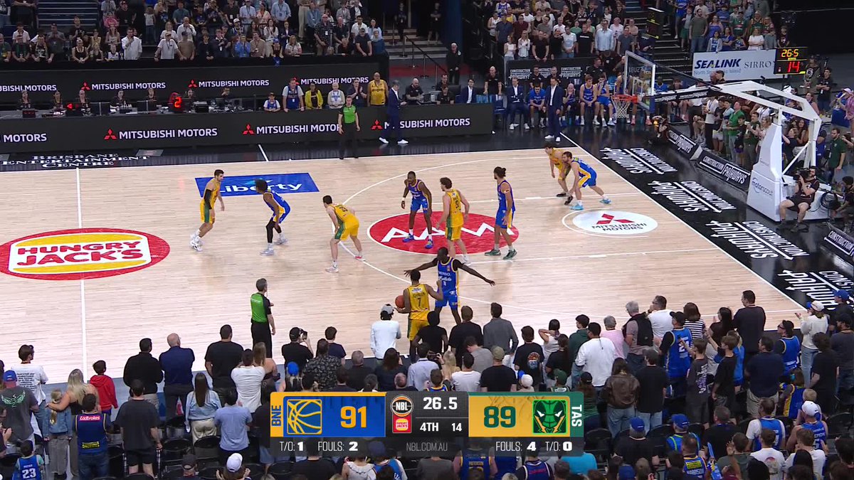 A packed stadium crowd watches the final seconds of an NBL basketball game between the Brisbane Bullets and Tasmania JackJumpers, with the scoreboard showing Brisbane leading 91-89 with 26.5 seconds left in the 4th quarter, a score that preceded Tasmania's overtime comeback win.