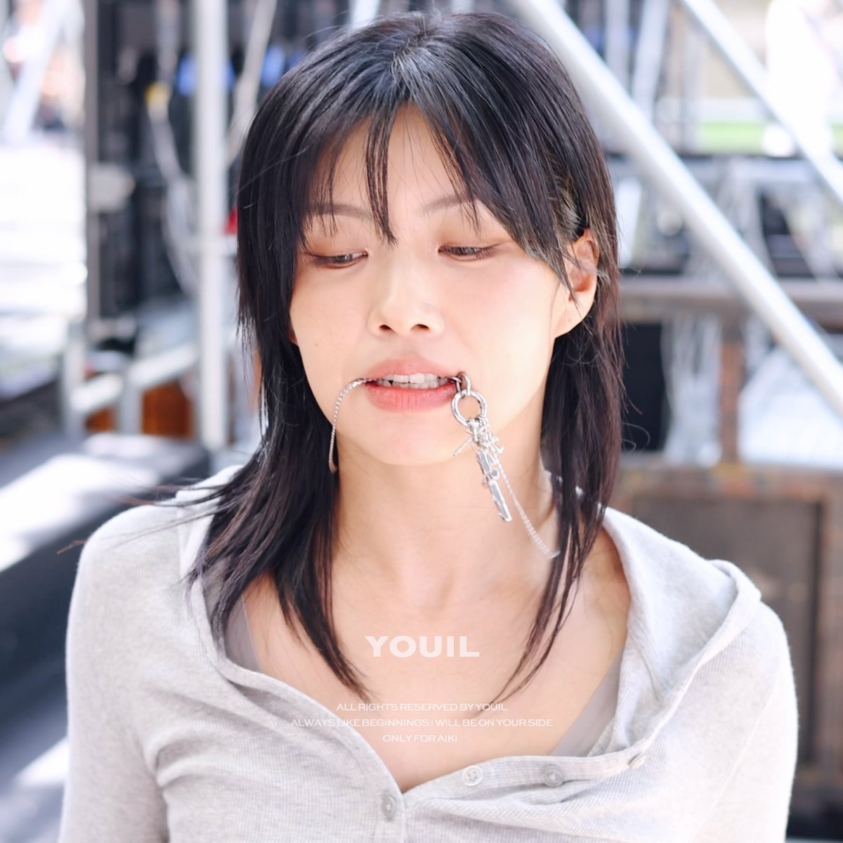 A close-up portrait of a young woman with dark hair biting a silver chain accessory; visible text reads "YOUIL", "ALL RIGHTS RESERVED BY YOUIL", "ALWAYS LIKE BEGINNING I WILL BE ON YOUR SIDE", and "ONLY FOR AIKI".