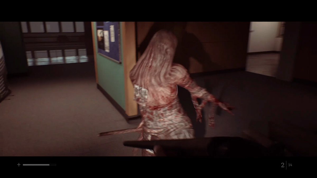 First-person gameplay screenshot from a horror game showing a grotesque, fleshy creature being attacked by the player who is holding a weapon.