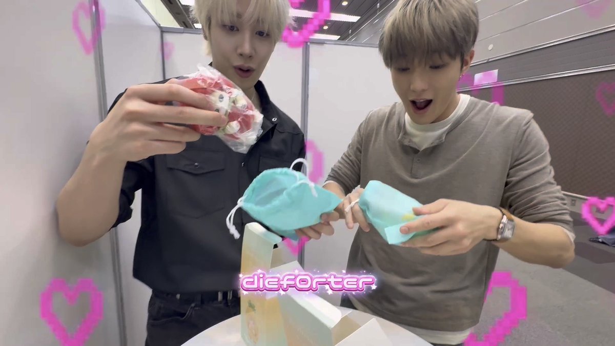 Two young men excitedly examine pastel-colored items and a wrapped package, with the text "dieforter" overlaid in pink stylized font surrounded by pink heart graphics, suggesting a promotional or unboxing moment that aligns with the post's enthusiastic, spoilery tone about a favorite named "Summer."