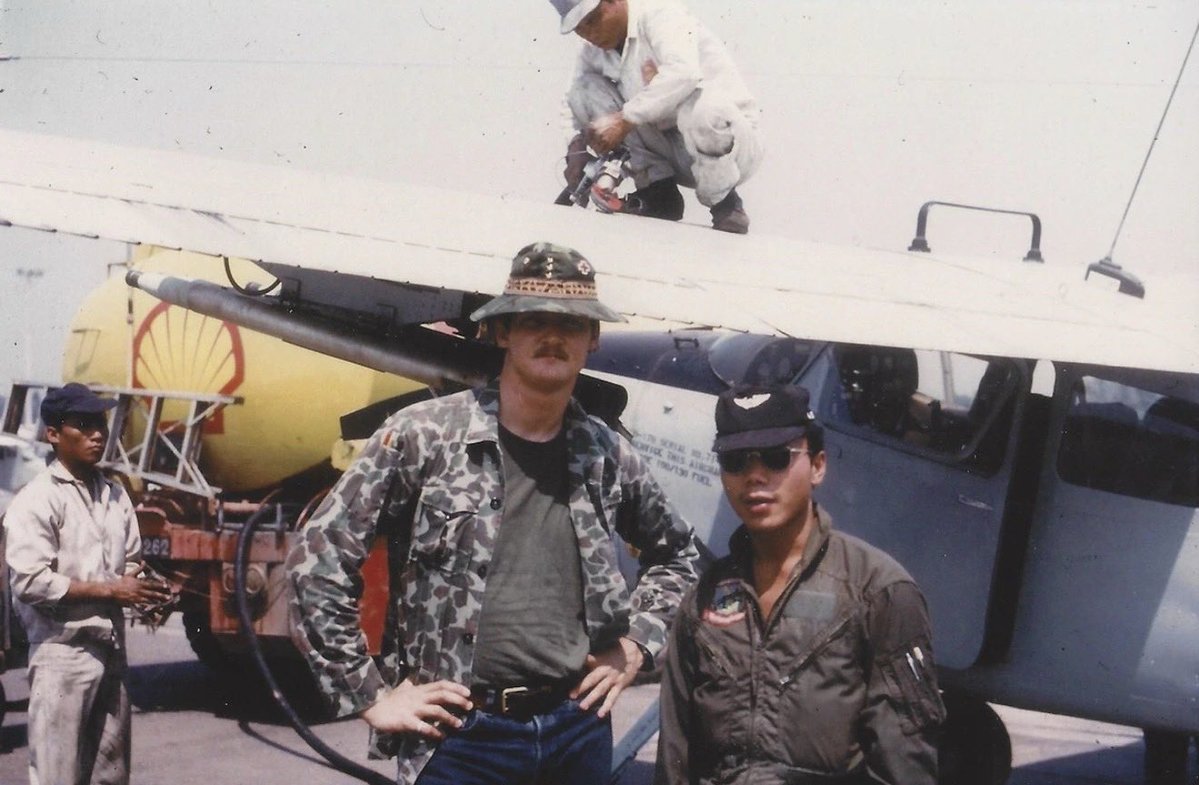 AircraftJunky's tweet photo. RAVEN 25 — THE AIR FORCE PILOT WHO WASN’T SUPPOSED TO BE THERE

The date beneath this photograph reads March 1973.

The man is Captain Darrel D. Whitcomb. Behind him is an unmarked O-1 Bird Dog. There is no uniform, visible rank or American flag, because officially, Whitcomb was not fighting a war in Laos.

A 1969 Air Force Academy graduate, Whitcomb had already flown the C-7 Caribou in Vietnam before returning as an OV-10 forward air controller known as Nail 25. Then he volunteered for the classified Steve Canyon Program and became Raven 25.

The assignment meant surrendering his military identification, changing into civilian clothes and entering Laos under embassy cover. Operating from Long Tieng, Whitcomb supported General Vang Pao’s CIA-backed Hmong army, flying low over the Plain of Jars to locate enemy forces, mark targets and direct American, Lao and Hmong aircraft onto them.

During an NVA attack on Skyline Ridge, friendly troops were caught in an ambush. Whitcomb repeatedly exposed his Bird Dog to enemy fire while directing strikes dangerously close to the men below. AK-47 rounds eventually tore through the aircraft’s oil system and killed the engine. He still managed to dead-stick the crippled O-1 back into Long Tieng.

The mission earned him the Silver Star.

Whitcomb was also photographed with Hmong T-28 pilot Touxiong Lee, whom he credited with saving his life during another mission, a reminder that the Ravens survived because Lao and Hmong airmen fought beside them.

After Raven operations ended, Whitcomb returned to the OV-10 and continued flying over Cambodia. On August 15, 1973, he was given the honor of being the last aircraft in his four-ship formation to land as America’s combat-air campaign there ended.

He later retired as an Air Force colonel and Delta international captain. But here he remains Raven 25: a young American pilot in civilian clothes, standing beside an aircraft without a flag, at the end of a war his country spent years pretending it was not fighting.

#AircraftHistoryJunky #RavenFAC #Raven25 #DarrelWhitcomb #SecretWar #LongTieng #O1BirdDog #Project404 #AviationHistory