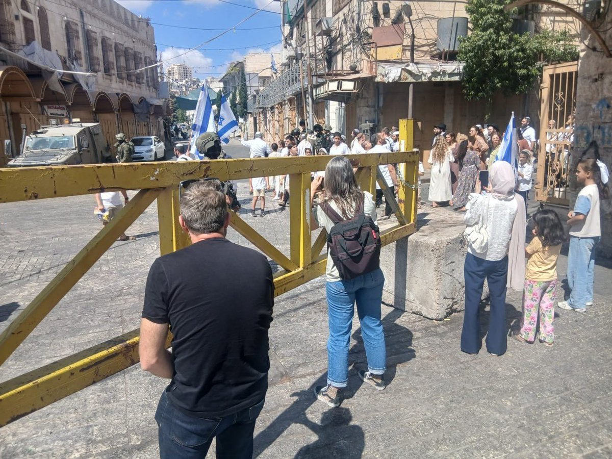QudsNen's tweet photo. Israeli settlers storm Hebron’s Old City under the protection of Israeli forces, in the occupied West Bank. https://t.co/hcTS8B2yoI