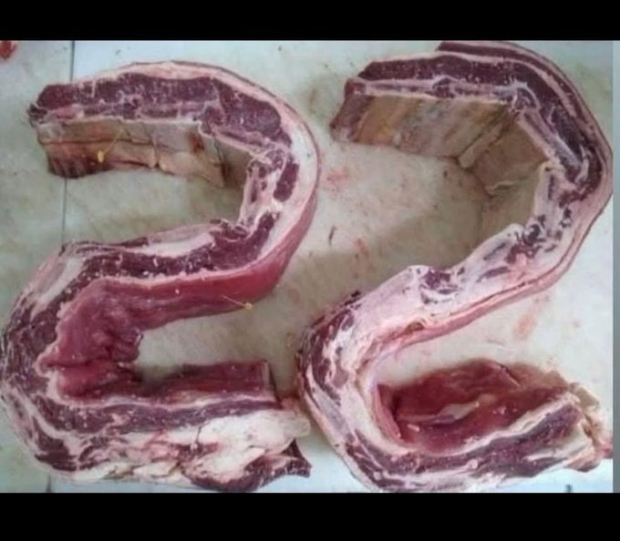 A large slab of raw red meat and white fat has been arranged on a tiled floor to form the shape of the number '32'.