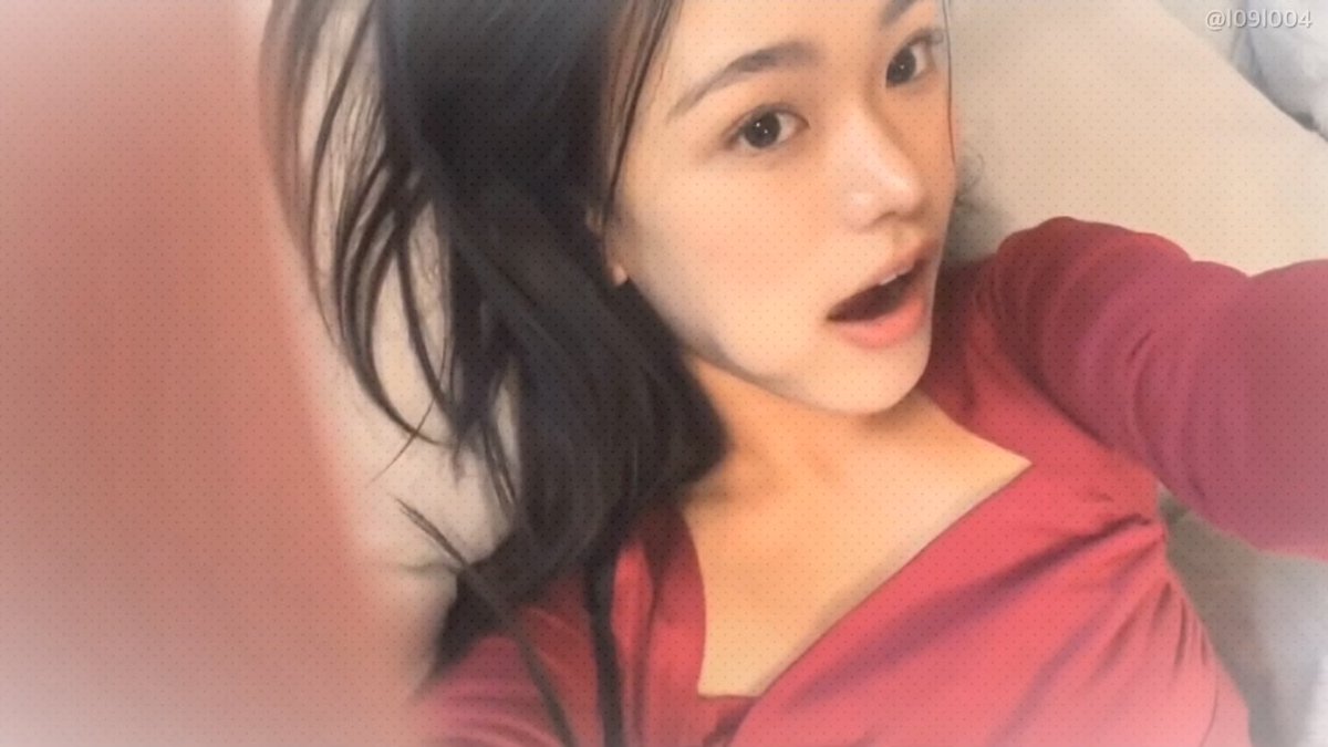 Selfie-style portrait of a young woman in a red top with a slightly open-mouthed expression, with the watermark '@1091004' visible in the corner.