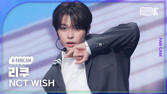 A fancam screenshot labeled 'K-FANCAM 리쿠 NCT WISH' showing a male performer in a dark suit pointing toward the camera.