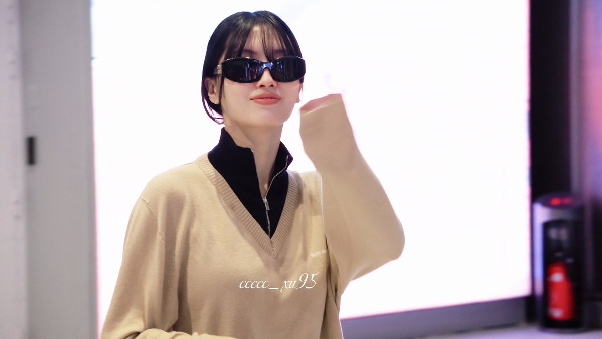 A young woman with short dark hair and black sunglasses poses wearing a beige sweater vest over a black top. A watermark reads 'ccccc_xu95'.