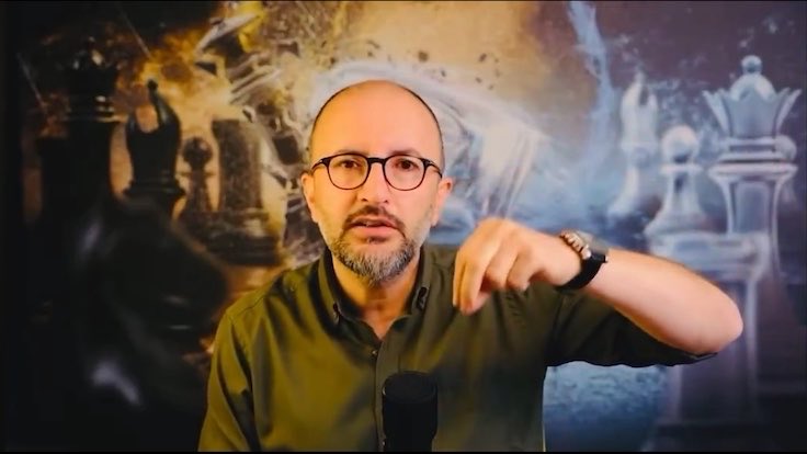 A bespectacled, bald man with a beard wearing a green shirt gestures emphatically while speaking into a microphone, set against a stylized background featuring chess pieces. The image appears to illustrate the post's message about the political chess match between President Erdoğan and Mayor İmamoğlu, visually reinforcing the strategic struggle described in the text.