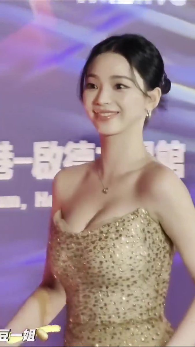 A woman in a gold sequined strapless dress, with partially visible Chinese text and the caption '豆一姐' in the bottom left corner.