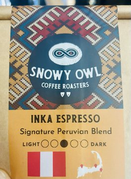 A package of 'SNOWY OWL COFFEE ROASTERS' branded coffee labeled 'INKA ESPRESSO - Signature Peruvian Blend' featuring a colorful geometric Peruvian textile pattern and a roast darkness indicator.