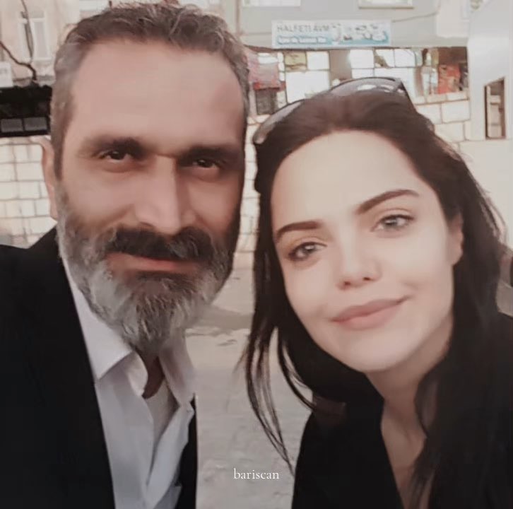 A bearded man in a dark suit and a dark-haired woman with sunglasses perched on her head take a close-up selfie together, with the watermark "barışcan" visible. The Turkish caption "hayatımın en büyük şoku oldu aq" (roughly "it was the biggest shock of my life") suggests the woman is sharing a surprising or memorable moment with the man, possibly a public figure.