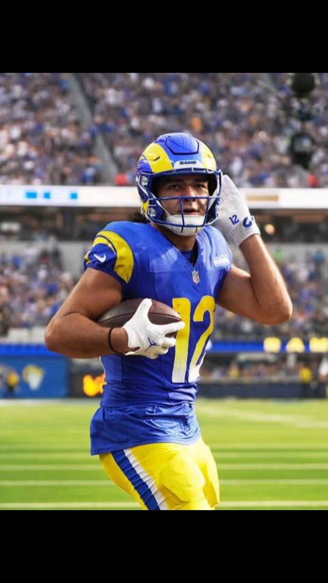 A football player wearing a blue and yellow Los Angeles Rams uniform with the number 17 holds a football while running on the field during a game.