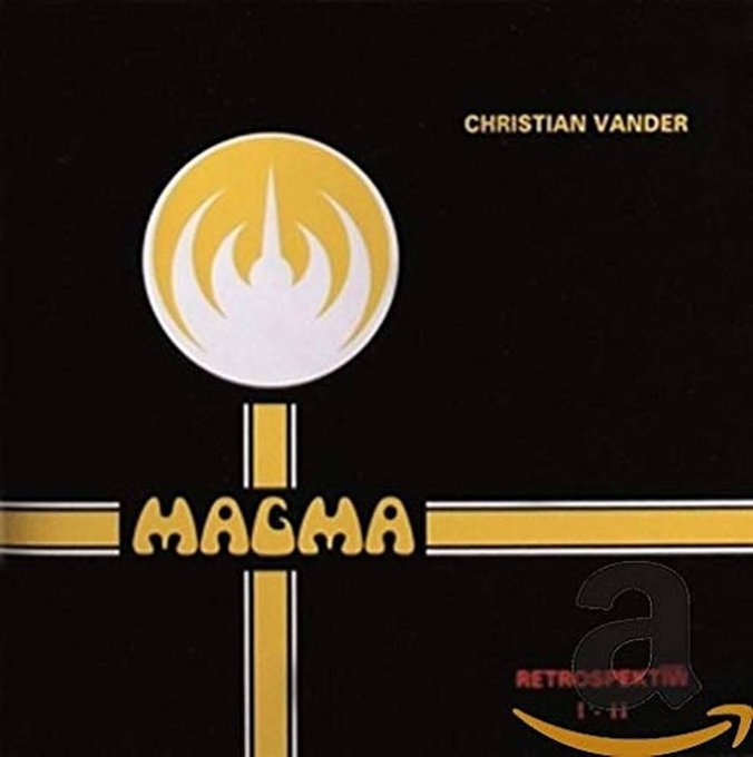 The album cover for Christian Vander's 'MAGMA' featuring a yellow and white flame-like sphere above a golden cross on a black background, marked with 'RETROSPEKTIV I-II' and an Amazon 'a' logo.