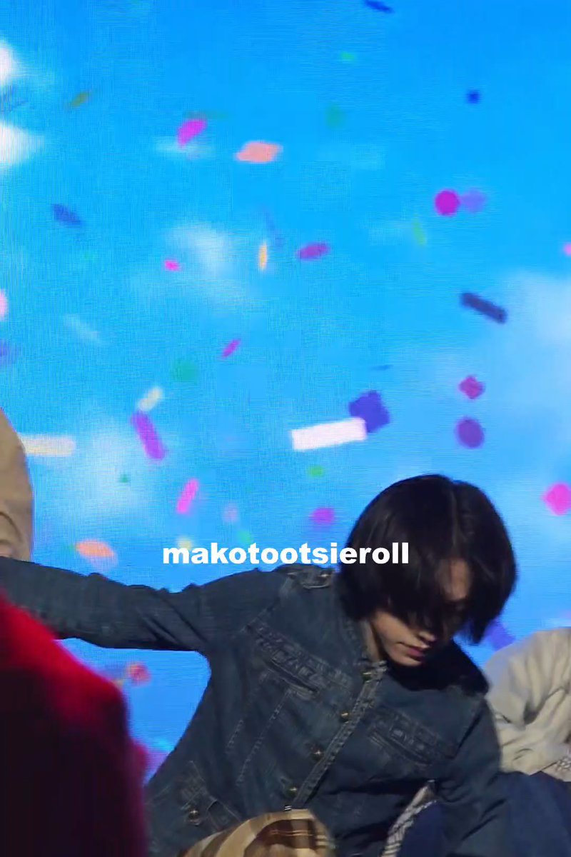 A screenshot from a video showing a person with dark hair wearing a denim jacket, with the text 'makotootsieroll' overlaid on a blue background with colorful confetti.