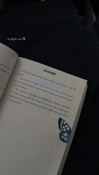 An open book showing a page titled "LOVE BEHIND YOU" with a blue butterfly resting on the page; overlay text reads "In-flight read 🦋".