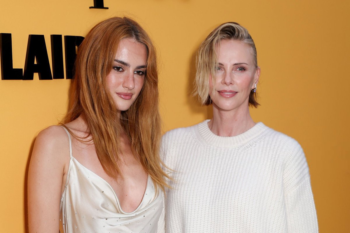 CharlieTheron04's tweet photo. Turned up at the Veuve Clicquot Club Solaire opening in Venice Beach, pairing a flowing white skirt with a relaxed knit and polished accessories. My latest appearance also highlights a very different side of her fitness journey. #CharlizeTheron #Hollywood https://t.co/btl0RAUEiB