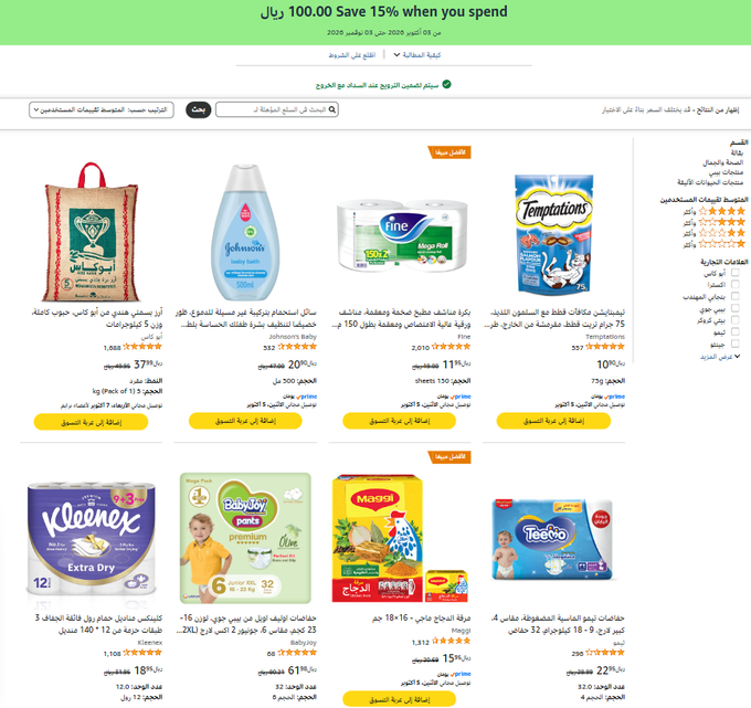 An Arabic-language e-commerce website screenshot showing various baby and household products for sale, including Kleenex tissues, Johnson's baby lotion, Fine toilet paper, Temptations cat treats, BabyJoy Pants diapers, Maggi products, and Teego diapers, with a banner offering 'Save 15% when you spend 100.'
