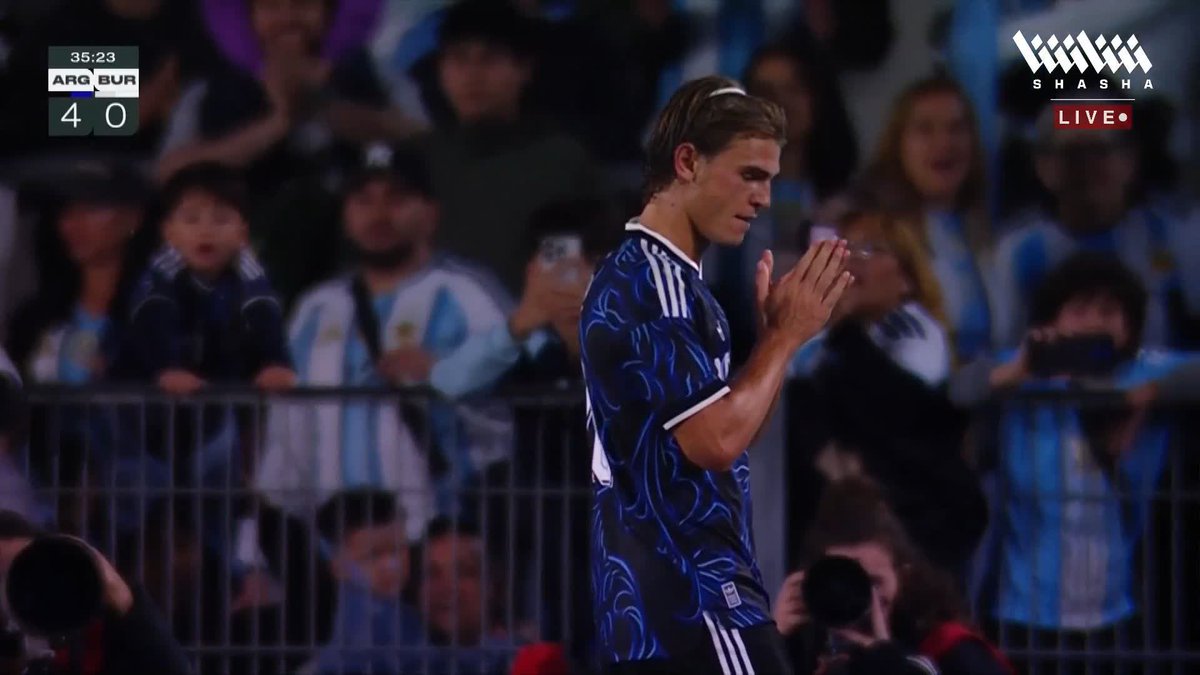 A screenshot from a Shasha Live broadcast of an Argentina vs. Burkina Faso match (ARG 4 - BUR 0 at 35:23), showing a player in a dark blue patterned Argentina jersey with hands clasped.