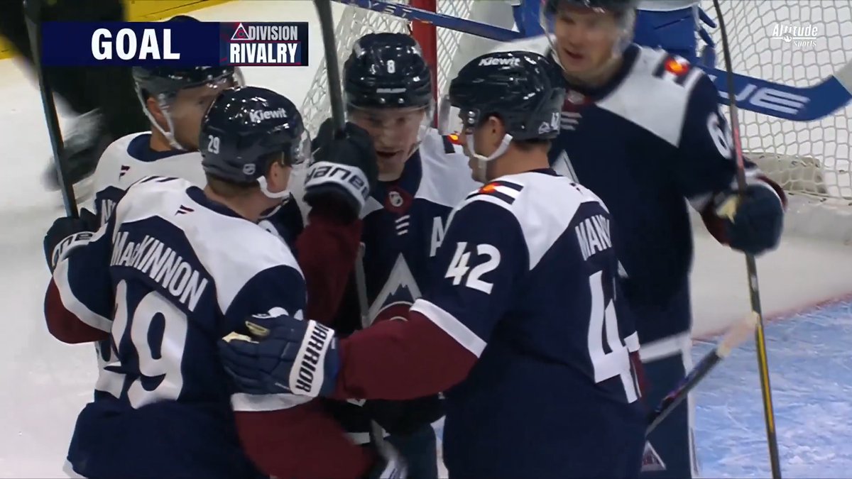 Colorado Avalanche players, including #29 MacKinnon and #42 Makar, celebrate a goal with "GOAL" and "Division Rivalry" graphics displayed on screen during an Altitude Sports broadcast. The image captures the team embracing near the net after scoring, matching the post's praise for MacKinnon, Necas, and Makar's perfect play.