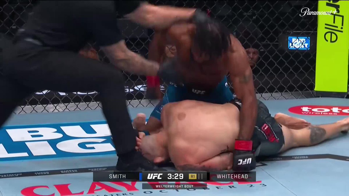 A UFC welterweight bout screenshot showing Smith vs. Whitehead at 3:29 in Round 1, with one fighter on top of another on the ground near a Bud Light logo, on Paramount+.