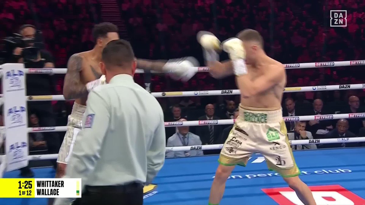 Two boxers trade punches in the ring during a professional match, with the on-screen graphic showing 1:25 remaining in round 1 of 12 between Whittaker and Wallace, broadcast live on DAZN. The DAZN watermark and Betfred ring branding confirm this is a live televised boxing event, matching the post's reference to the Whittaker vs. Wallace bout airing now on the streaming platform.