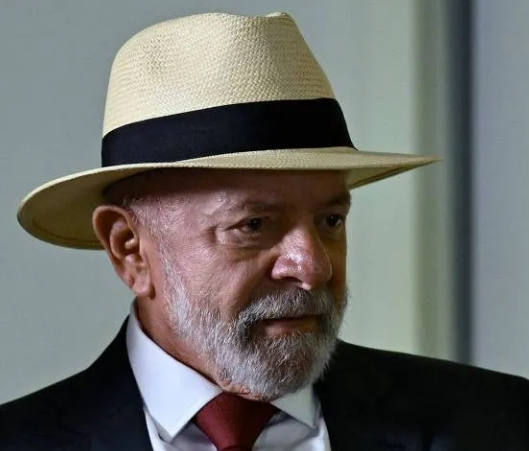 An older man with a white beard wearing a Panama-style straw hat, dark suit, and red tie is shown in profile, corresponding to Brazilian President Lula, who the caption references as having lost 11.62 percentage points of voter support in Bahia compared to 2022.
