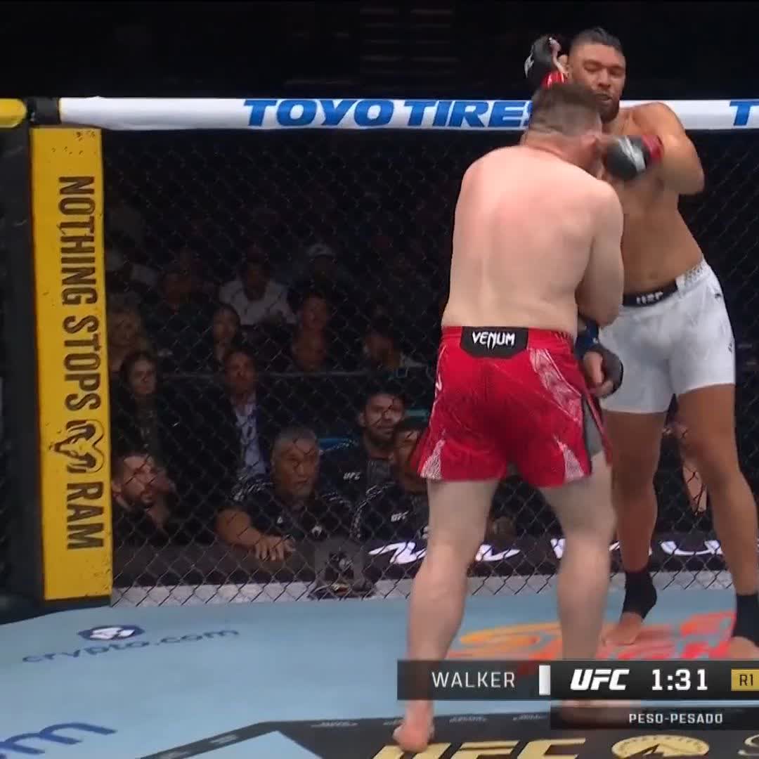 Two UFC fighters battle inside the octagon, with one landing a powerful punch to the other's face, as the on-screen graphic displays "WALKER 1 UFC 1:31 R1" and "PESO-PESADO," capturing the moment of Johnny Walker's dominant debut in the heavyweight division.