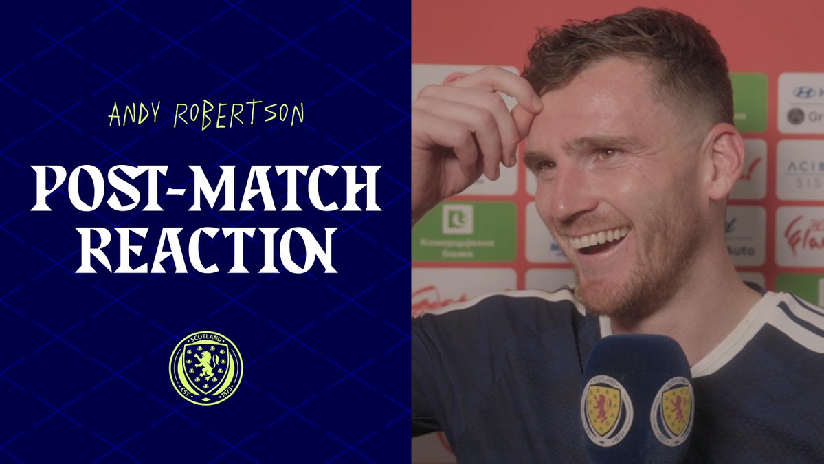 Andy Robertson is shown smiling and wiping sweat from his forehead during a post-match interview, with the graphic "Andy Robertson Post-Match Reaction" and Scotland's national team crest displayed on the left side of the image.